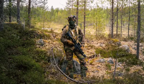 Fransk soldat i full stridsutrustning i finsk skogsmiljö.